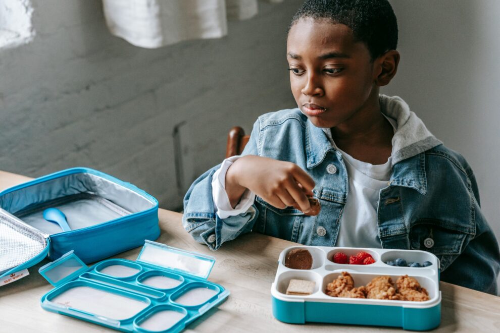 Student with lunch box in classroom